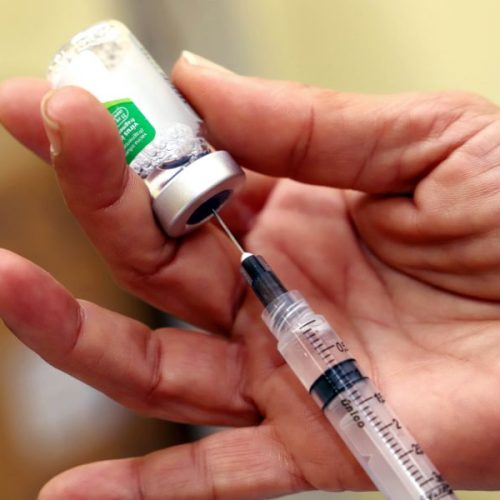 mão puxando líquido de imunizante na serings