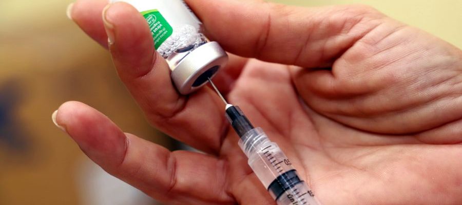 mão puxando líquido de imunizante na serings
